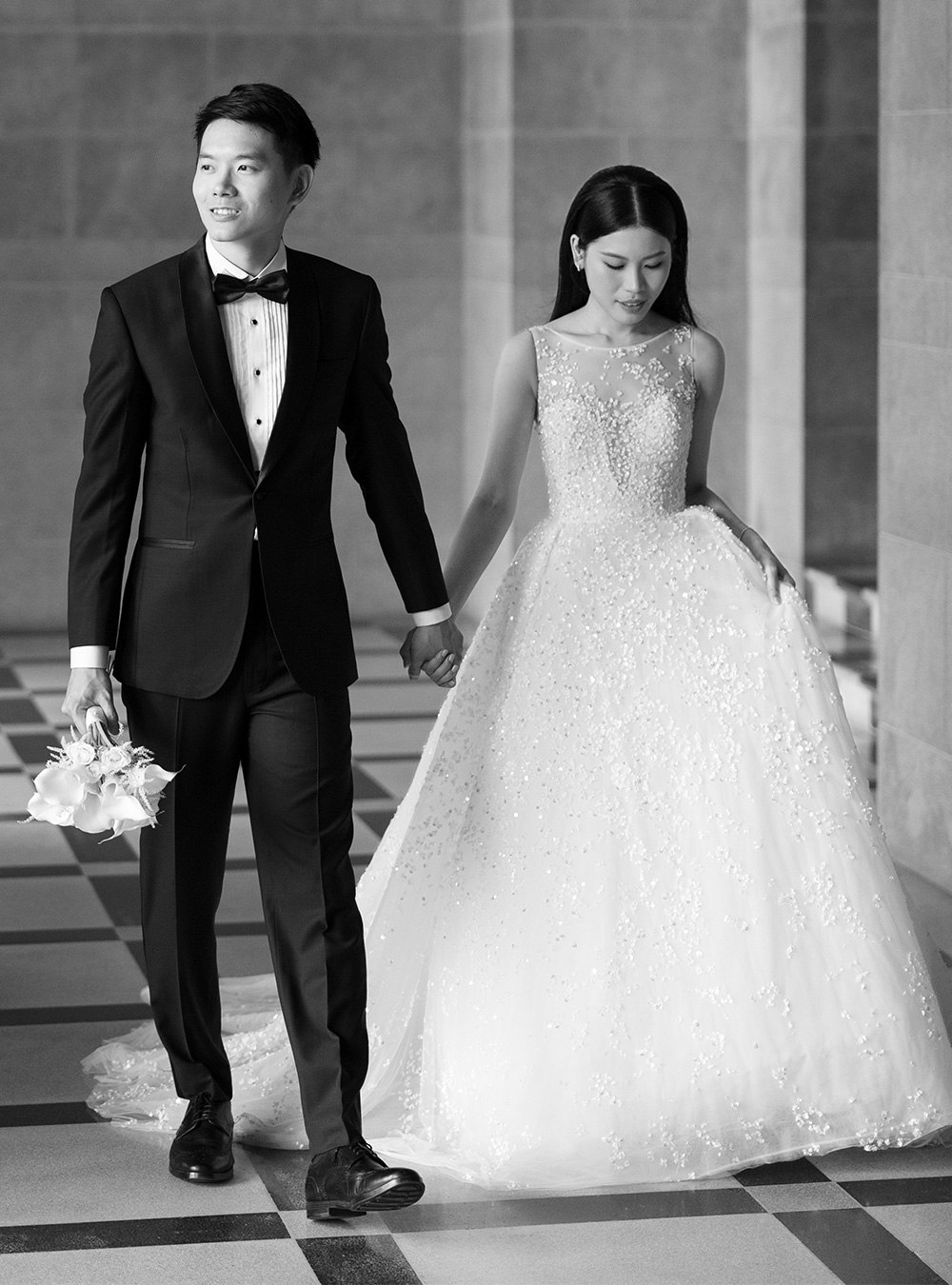 Perfect Attire | Wedding Suits & Tuxedos Singapore Groom in a black tuxedo walking with his bride